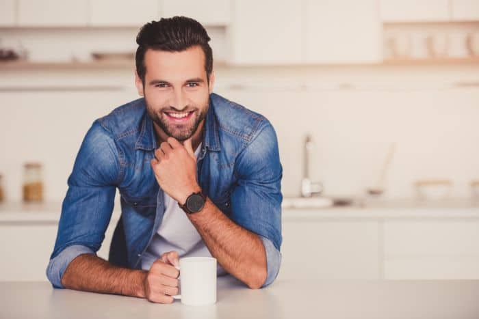 Attractive man drinking coffee in his kitchen